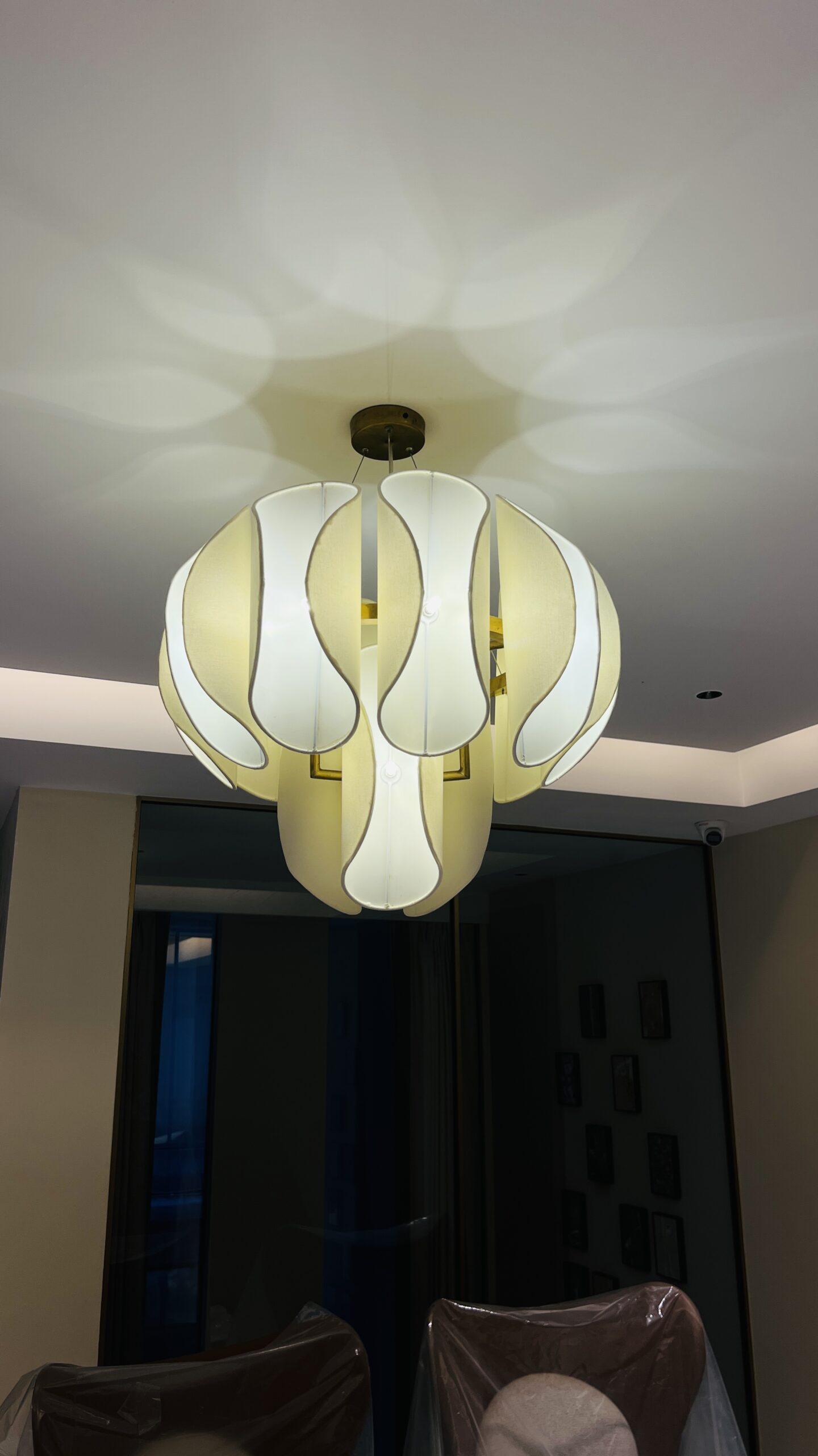 Technicians installing a bespoke chandelier in a luxury interior