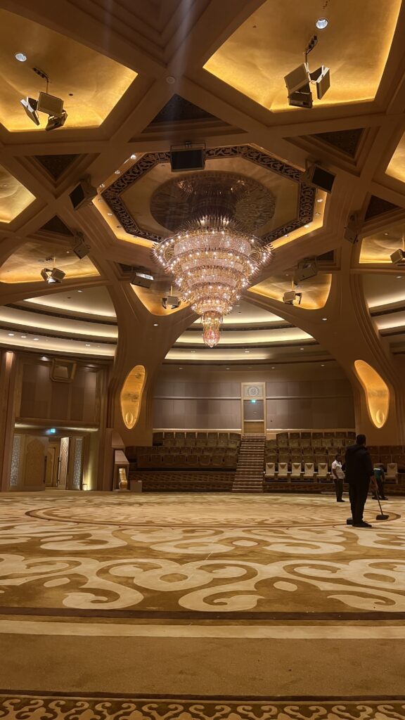 Banquet hall set for an event under warm chandeliers